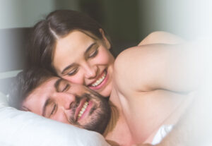 <pareja-feliz-abrazada-en-la-cama>