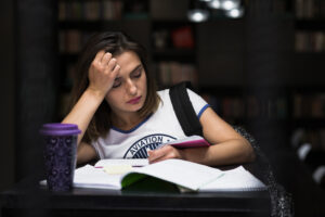 <muchacha-que-se-sienta-en-la-tabla-con-la-lectura-de-los-cuadernos>