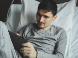 <un-joven-paciente-con-una-tableta-en-la-sala-del-hospital>