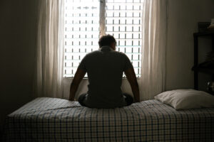 <hombre-desesperado-en-silueta-sentado-en-la-cama-solo-concepto-de-masculinidad-y-emasculacion>