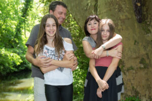 <familia-joven-feliz-con-dos-ninos-al-aire-libre>