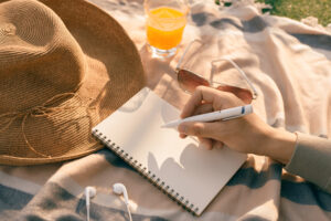 <horario-de-verano-manos-con-lapiz-escribiendo-en-un-cuaderno-en-el-parque>